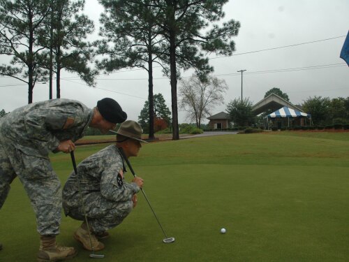 Two Army soldiers in fatigues evaluate a hole at Fort Jackson Golf Course