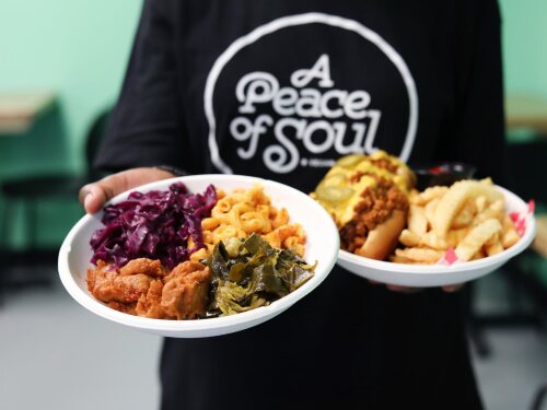 Peace of Soul employee holding two plates of food