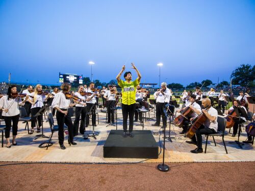 The conductor guiding the musicians at the annual Annual Fireworks with the Phil event at Segra Park.