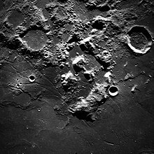 Black and white photo of a created surface of the Moon showing the landing site and surrounding area for Apollo 17 as taken from Apollo 17.