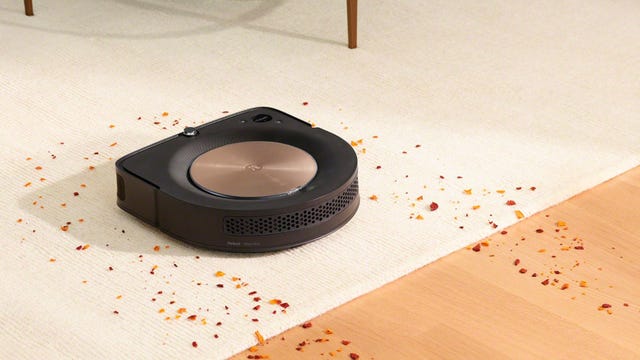 The Roomba s9 Plus robot vacuum cleaning crumbs on both carpet and hardwood floors.