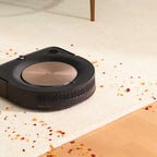 The Roomba s9 Plus robot vacuum cleaning crumbs on both carpet and hardwood floors.