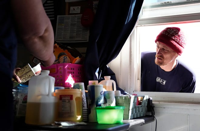Jacob Melanson, right, who has struggled with drug addiction on and off since 2006, waits for hot coffee that Teresa Routte is making at the HOPE Resource Center on the Hilltop.