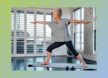 mature woman doing lunge yoga exercise at home in bright living space next to windows