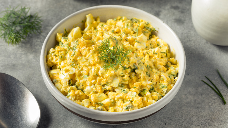 Egg salad in bowl with herbs