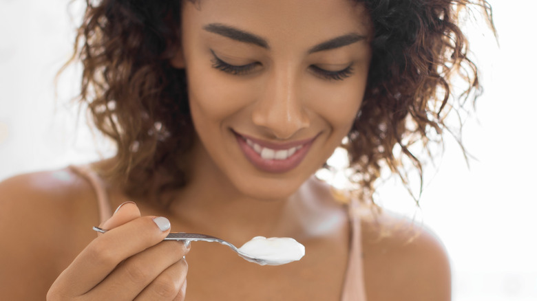 woman eating spoonful of yogurt