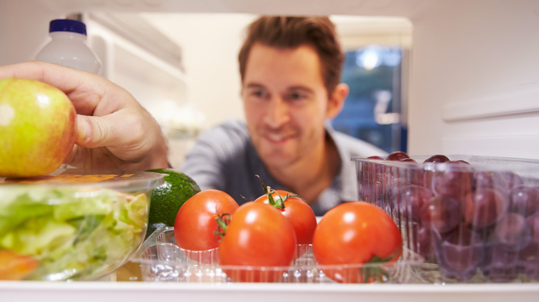 Man choosing fruit from refrigerator
