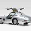 A silver 1955 Mercedes-Benz 300SL Gullwing with doors open parked in left ear angle view on white surface white background