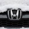 The Honda logo on the grille of a snow-covered SUV