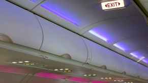Airplane cabin lights with "exit" sign illuminated