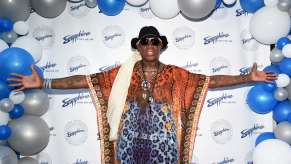 Basketball player Dennis Rodman poses for a photo on the red carpet.