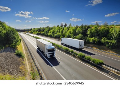 Cargo truck driving through landscape at sunset Stock Photo