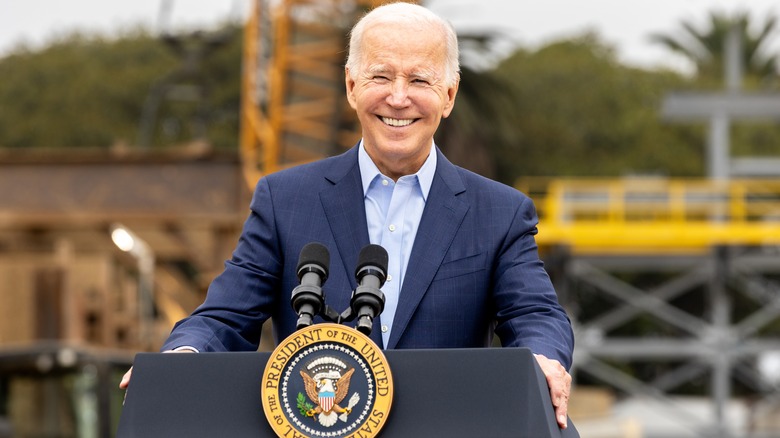 Joe Biden at podium outdoors smiling