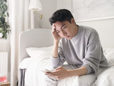 distressed man sitting on bed