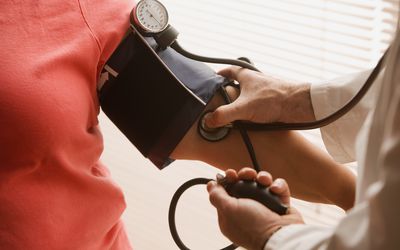 A healthcare provider checking a woman's blood pressure