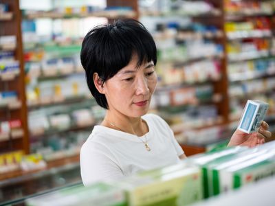 An Asian woman buys medicine at a pharmacy