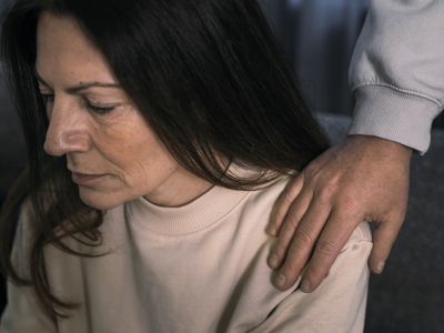 Man putting hand on the shoulder of a depressed woman