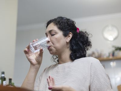 Female taking medication with water