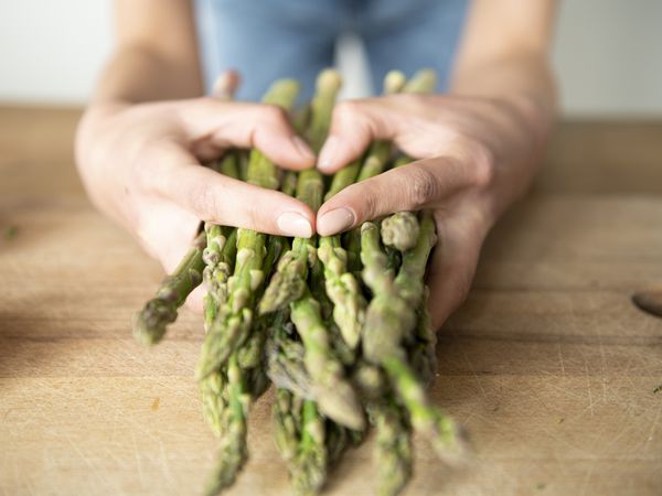 A woman holding fresh asparagus