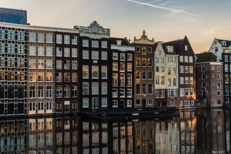Traditional Amsterdam canal houses reflecting in the water, representing the home of the innovative SEO Agency