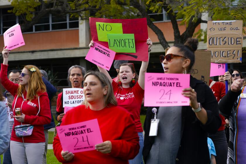 San Diego, CA - March 26: Lindsey Stamper, a music teacher at Oak Park, Whitman, and Dailard Elementary Schools, showed her support for her 226 colleagues who were recently given layoff notices. A large group gathered at the San Diego Unified School District office on Tuesday, March 26, 2024, in San Diego to hold a rally and attend the board’s meeting, where they staged a silent demonstration holding up symbolic pink signs. (Nelvin C. Cepeda / The San Diego Union-Tribune)