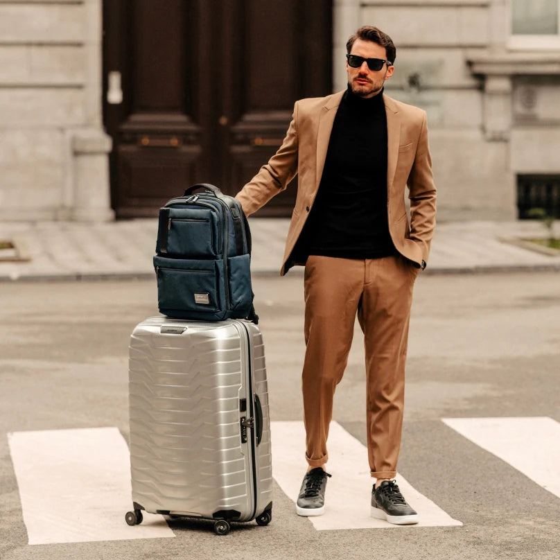 Well-dressed man with a Samsonite suitcase and backpack