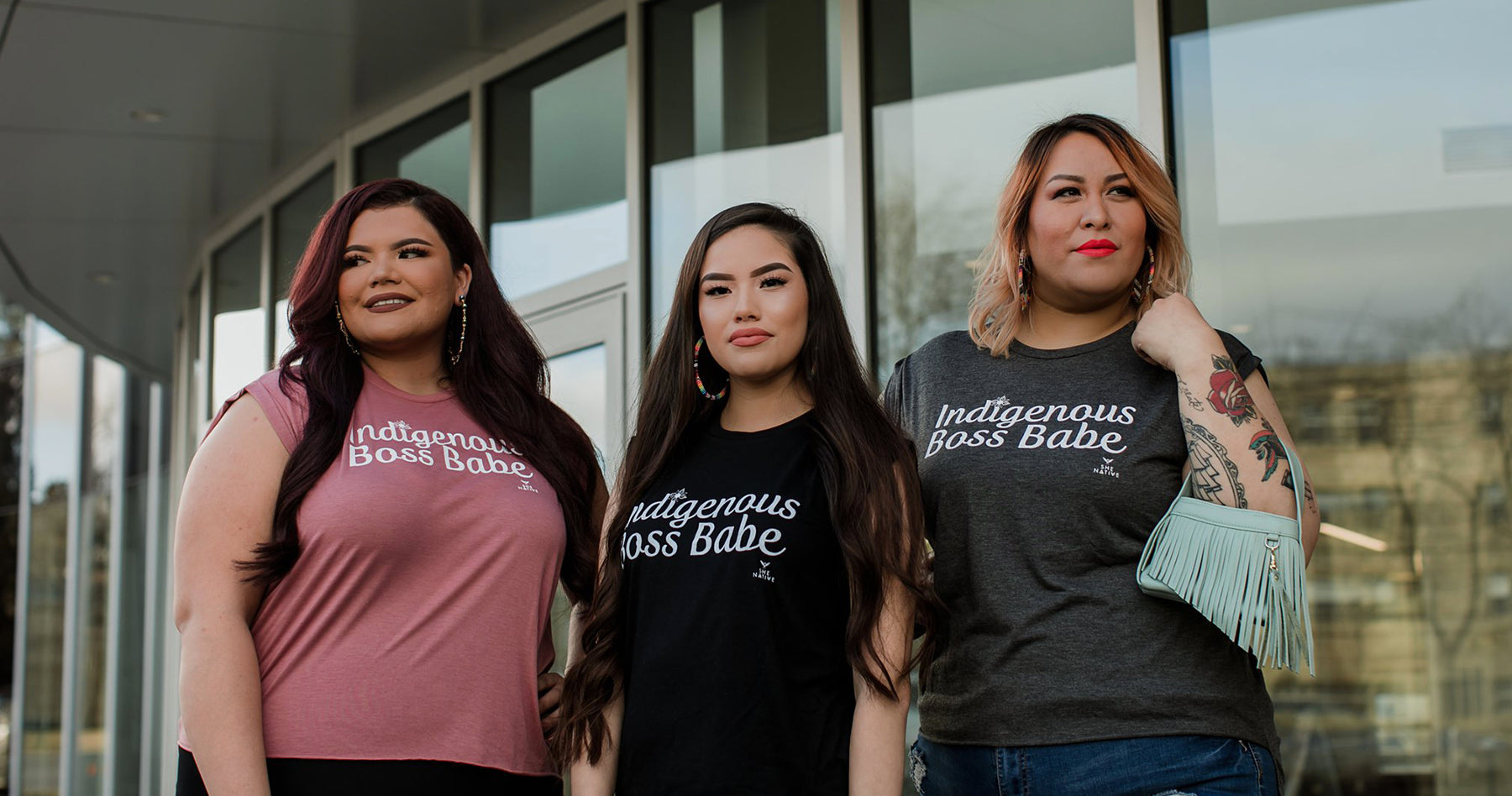 Photograph of three Indigenous women wearing t-shirts that read Indigenous Boss Babe created by the brand SheNative