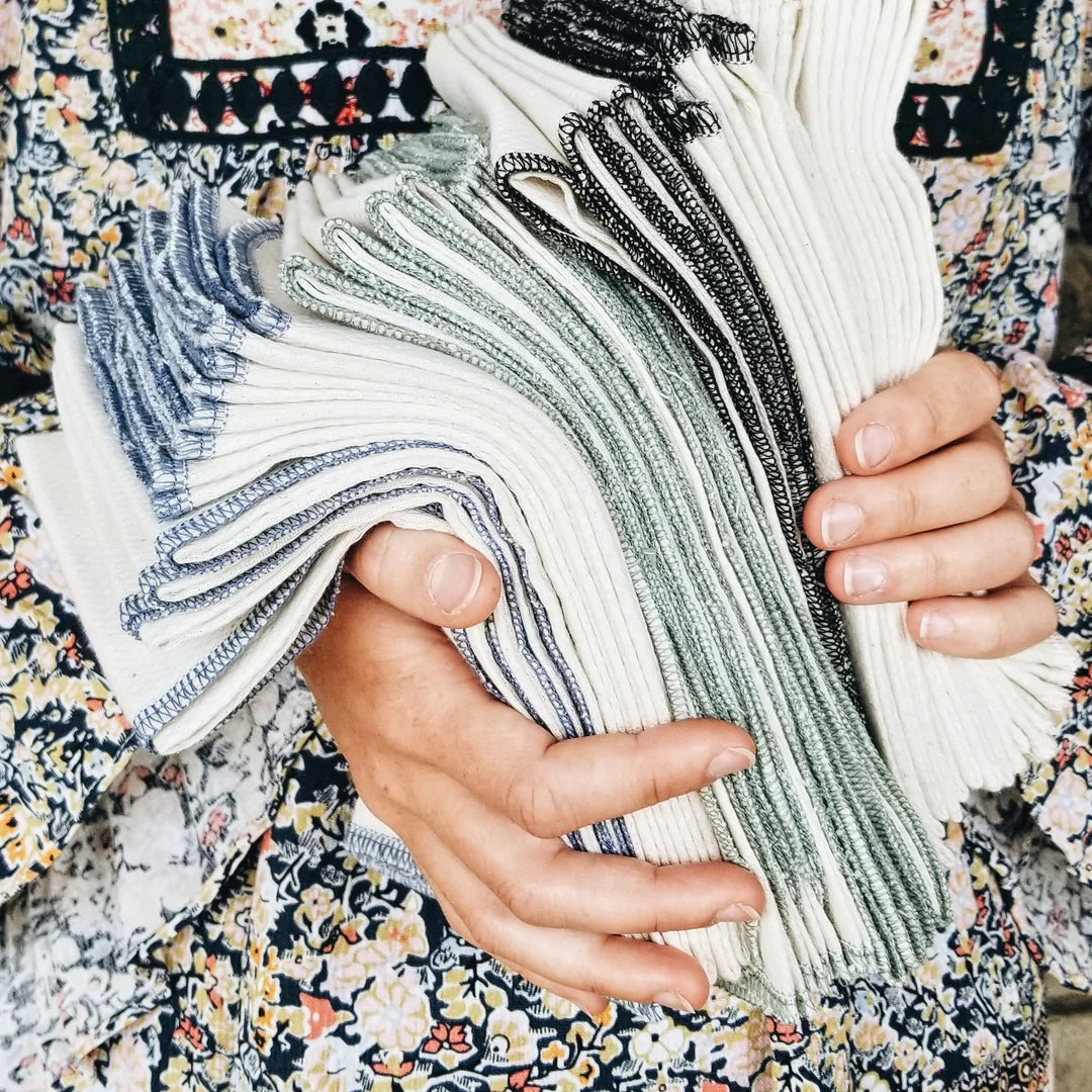 Close up of hands holding a stack of tea towels