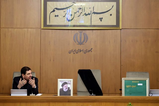 Leerer Platz (20.5.2024) Irans bisheriger Vize-Staatspräsident Mohammed Mokhber sitzt neben dem leeren Platz des verstorbenen Präsidenten Ebrahim Raisi und dessen Porträt. Bei einem Hubschrauber-Absturz waren Raisi, Außenminister Hossein Amirabdollahian und sieben weitere Personen ums Leben gekommen. Das geistliche Oberhaupt des Landes, Ali Khamenei, erklärte Mokhber zum Interims-Staatschef und verfügte eine fünftägige Staatstrauer.