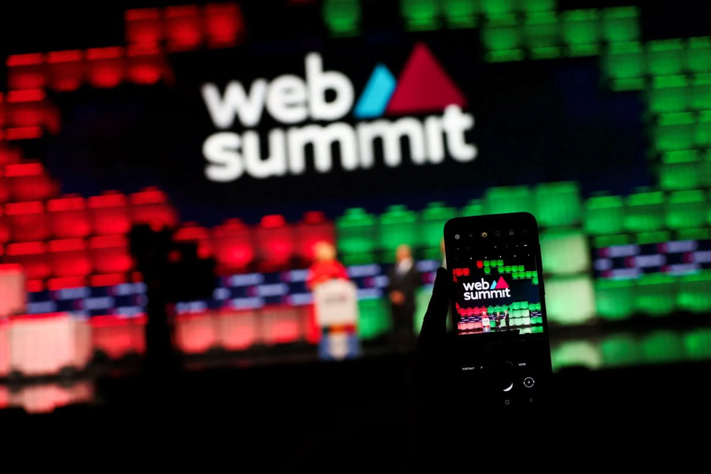 A man takes a picture of the centre stage of Web Summit, in Lisbon, Portugal, November 13, 2023. REUTERS/Pedro Nunes