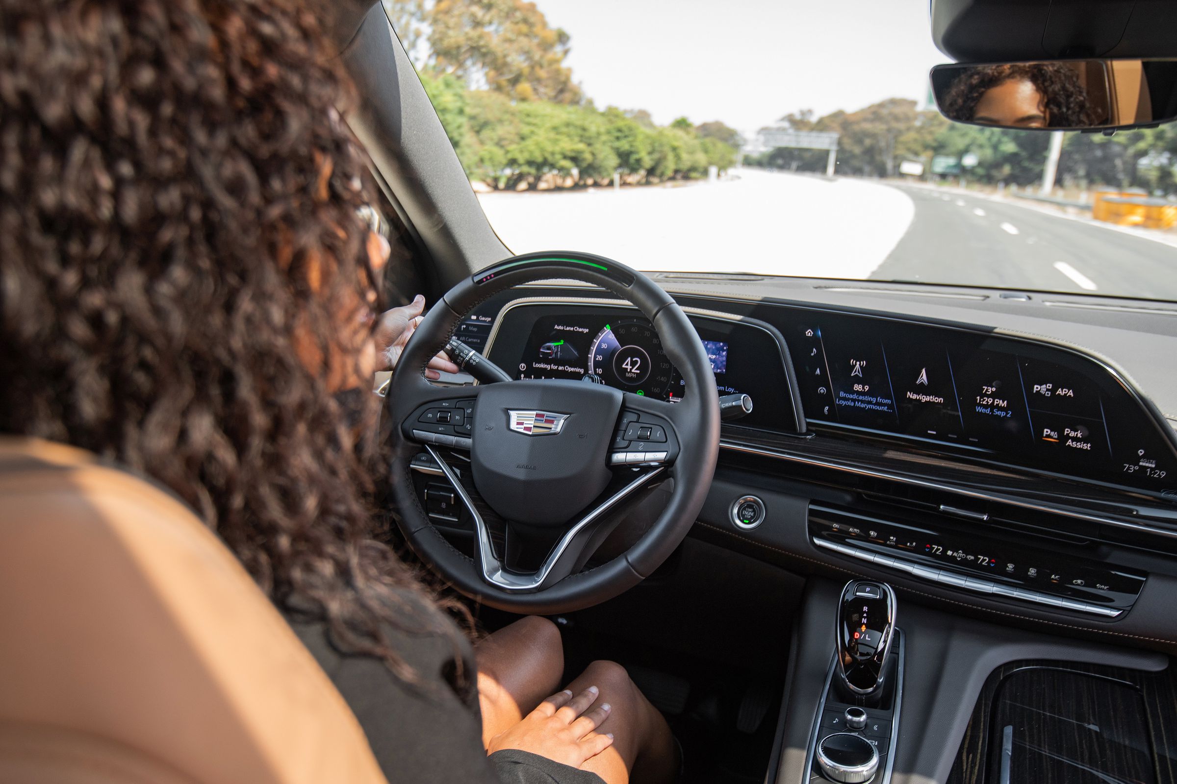 Over-the-shoulder shot of a person using Super Cruise, GM’s hands-free driver-assistance technology, in a Cadillac Escalade.