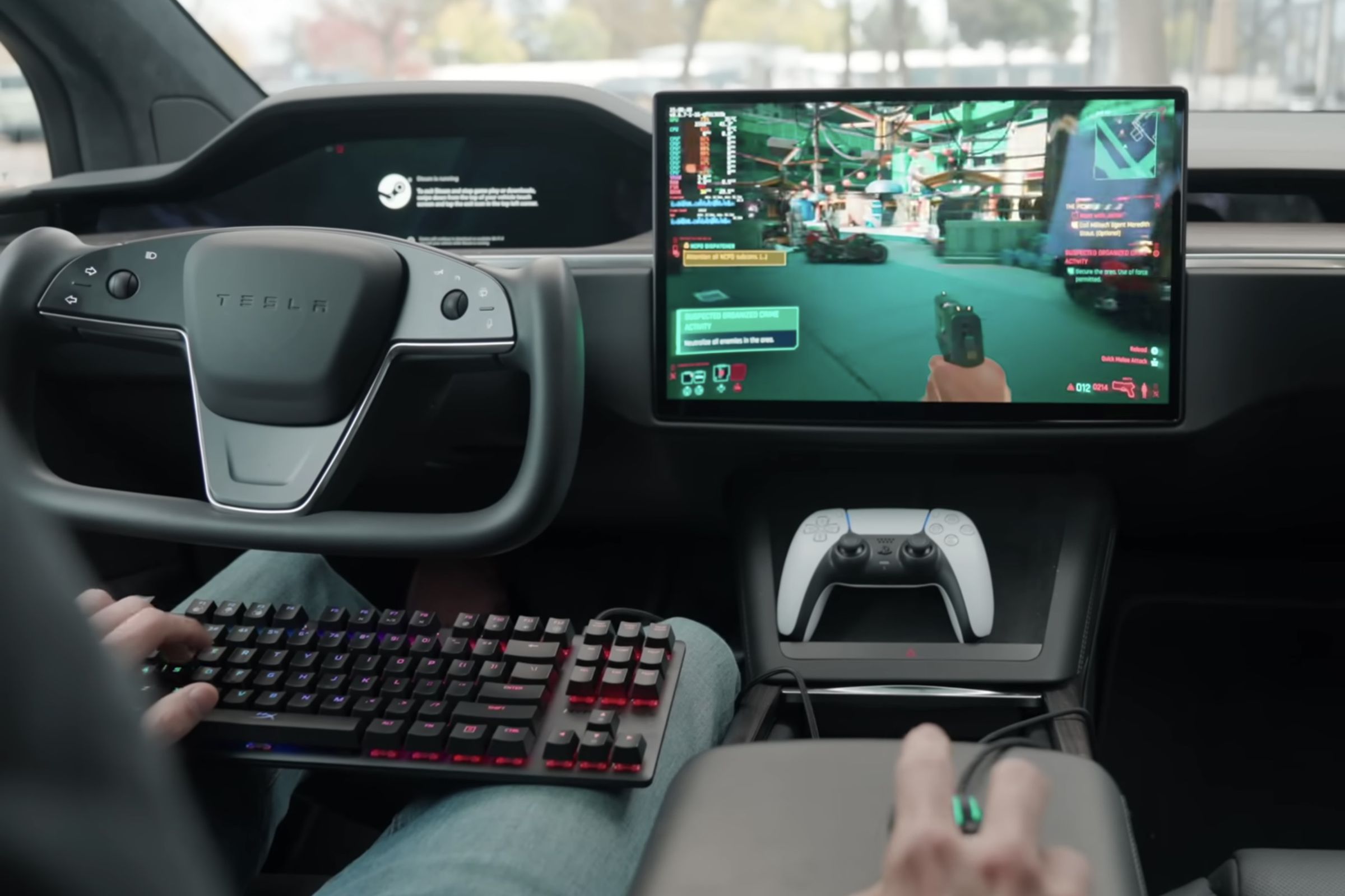 INT: driver of a Tesla model S with yoke steering wheel is parked and playing Cyberpunk 2077 steam game on the car’s infotainment screen while using a gaming keyboard in his lap, a mouse on the arm rest, and a PS5 controller sitting in the center console.