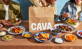 people eating on a table wit CAVA logo in view_CAVA