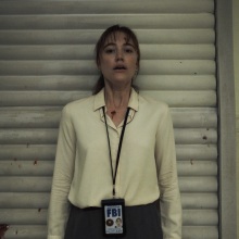 Maika Monroe stands against a garage door looking terrified in the film "Longlegs".
