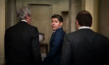 Sam Altman looks behind him with a startled expression, walking through the U.S. Capitol building.