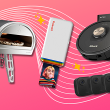 Roccbox pizza oven, Polaroid photo printer, Shark robot vacuum, and Blink security cameras with pink background