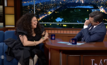 Michelle Buteau and Stephen Colbert giggle during an interview on "The Late Show."