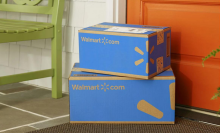 Two Walmart packages sitting on porch in front of orange door