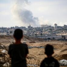 Boys watch smoke billowing during Israeli strikes east of Rafah in the southern Gaza Strip.