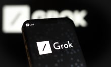 A phone displaying the Grok xAI logo, which is a white box with a black slash across it. 