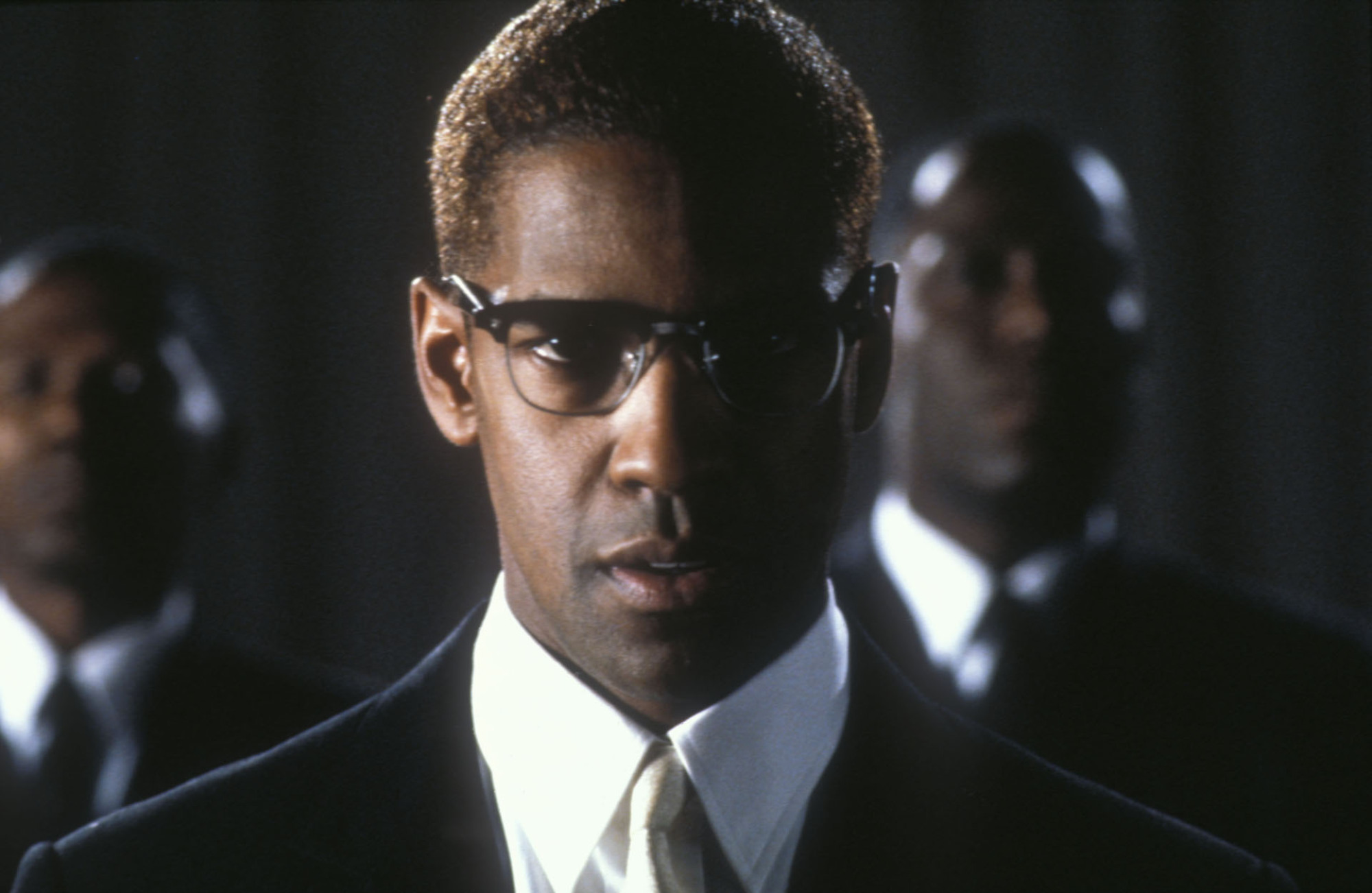 A Black man wearing a suit faces forward