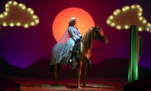 Malala Yousafzai sits on a fake horse in the show "We Are Lady Parts"