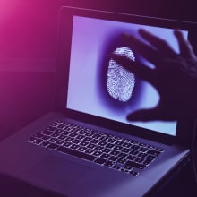 A laptop displaying a large fingerprint on its screen.