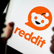 The Reddit logo is visible in the background, while the silhouette of a woman using a smartphone can be seen in the foreground.