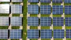 Aerial view of solar panel arrays on a grassy roof.