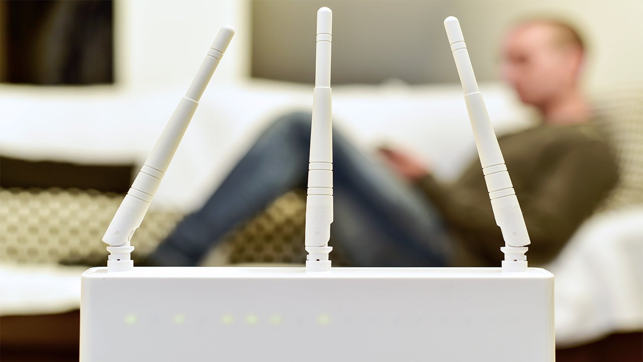 closeup of a wi-fi router with a person sitting in the background