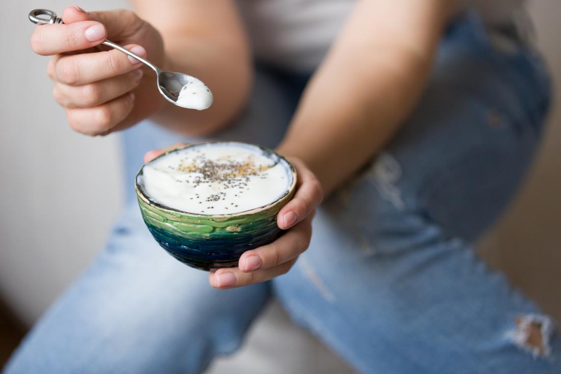 Woman eating yogurt out of bowl