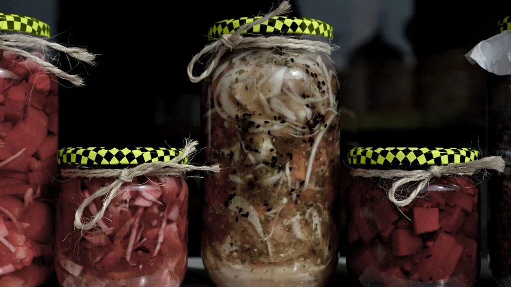 Jars of various sizes full of fermented foods such as sauerkraut and kimchi