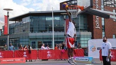 A basketball player about to score a basket through the basketball hoop located at Liverpool One 