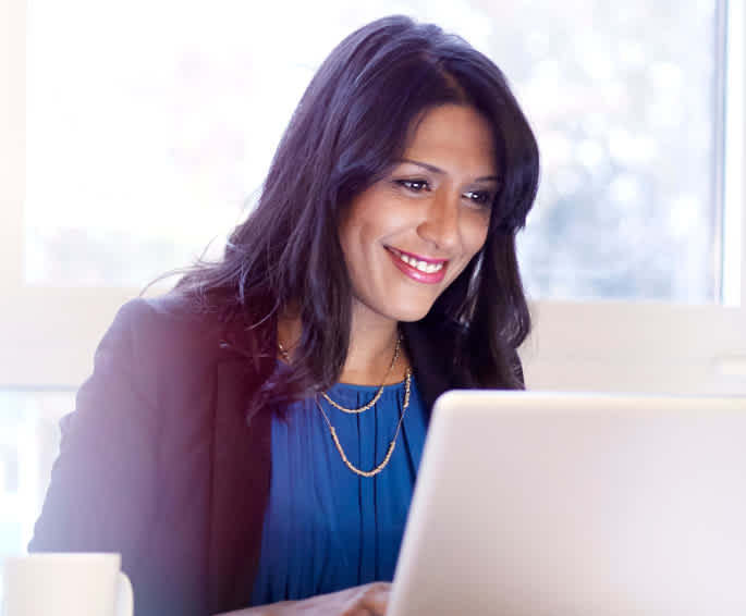 Woman working on a laptop and smiling